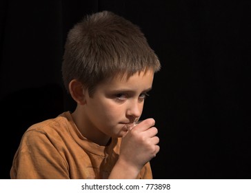 Young Boy Sneaking Alcohol, On Black Background