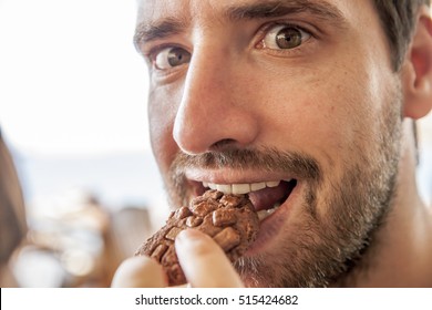 young  boy sneaking a cookie into his mouth