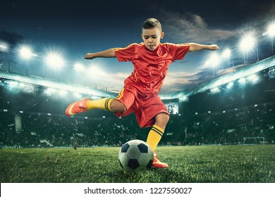 Young Boy With Soccer Ball Doing Flying Kick At Stadium. Football Soccer Players In Motion On Green Grass Background. Fit Jumping Boy In Action, Jump, Movement At Game. Collage