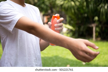 Young Boy Spraying Insect Repellents On Skin In The Garden With Spray Bottle