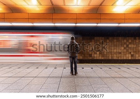 A young boy standing on a subway platform as the train speeds past, capturing the urban energy, public transport experience, and the anticipation of travel in a bustling city setting.