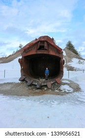 Young Boy Stay Inside The Old Rusty Giant Bucket Of Mining Excavator 