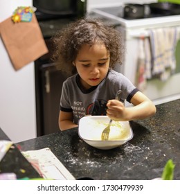 Young Boy Stirring Batter In The Kitchen