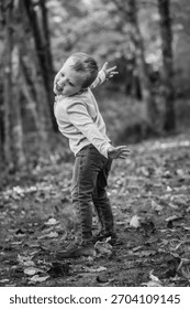 A young boy strikes a pose while dancing outdoors at a park