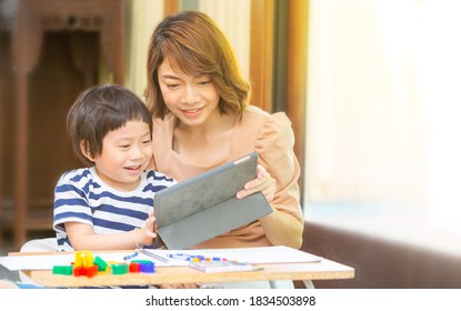 A Young Boy Studies At Home With His Mom. Home School Distance Learning And Happy Learning Online Education Concept