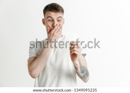 Young boy with a surprised unhappy failure expression bet slip on studio background. Human facial emotions and betting concept.