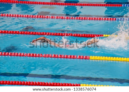 Young boy swimming Freestyle posture in the blue water pool