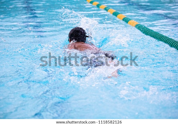 Young Boy Swimming\
Laps in a Pool in Summer