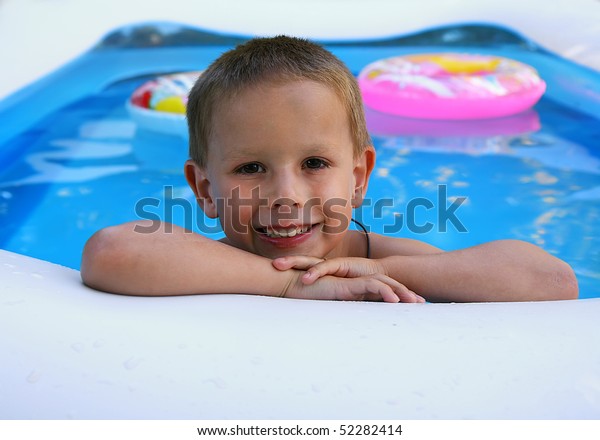 a young boy swimming
in a small pool