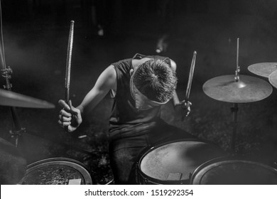 Young Boy As Talented Rock Band Drummer . Handsome And Cool Asian American Teenager In Headband Playing Drum Kit Performing Night Music Show As Hobby In Teenage  Love For Music 