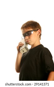 A Young Boy Talks On A Old 1980s Era Brick Cell Phone Isolated On White