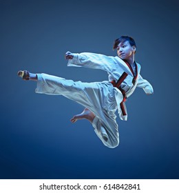 Young boy training karate on blue background