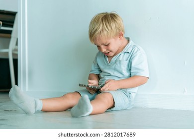 Young boy using smartphone alone illustrating excessive screen time digital device dependency child technology addiction online entertainment parenting and modern family lifestyle