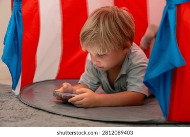 Young boy using smartphone alone illustrating excessive screen time digital device dependency child technology addiction online entertainment parenting and modern family lifestyle