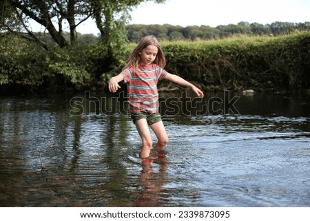 Young boy wading in a stream 