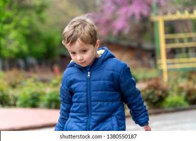 Young boy walking around in a outdoors park