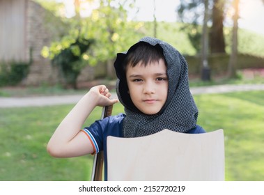 Young Boy Wearing Knight Costume Holding Sword Shield Standing In The Park, Happy Kid Pretending To Be A Medeival Warrior, Active Kid Having Fun Playing Or Doing Outdoor Activityvon Spring Or Summer