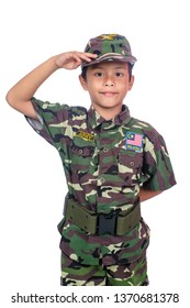 A Young Boy Wearing A Malaysian Army Costume And A Toy Gun Isolated On White Background