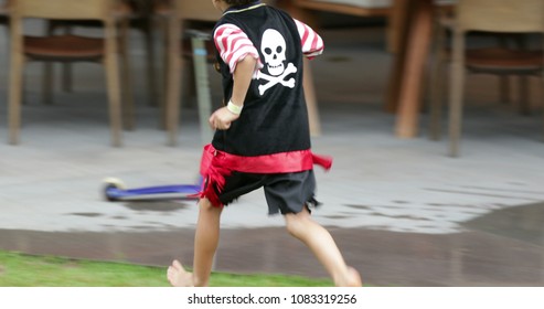 Young boy wearing pirate costume runs in the outdoor garden - Powered by Shutterstock