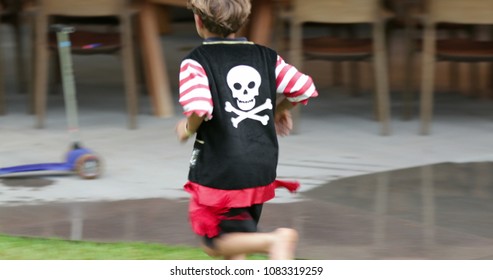 Young boy wearing pirate costume runs in the outdoor garden - Powered by Shutterstock