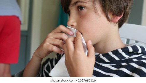 
Young Boy Wiping Mouth With Napkin