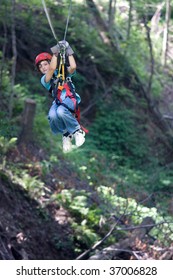 Young Boy Is Ziplining In The Forest