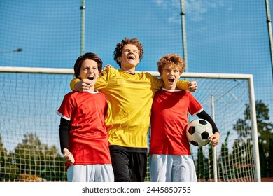 young boys, all dressed in soccer jerseys, stand closely together in unity on a green soccer field. Each boy is looking in different directions, some talking and laughing, while others are focused and - Powered by Shutterstock