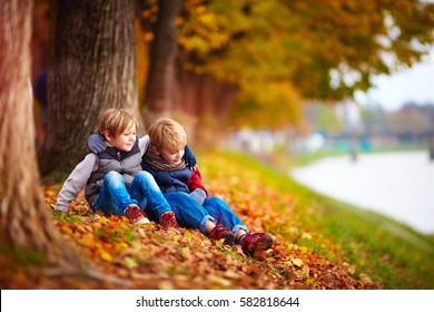 Young Boys, Best Friends Sitting Under The Tree In Autumn Park