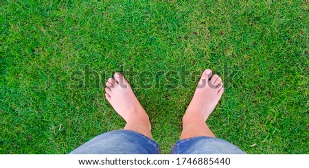 Young boys legs standing on green grass having fun outdoors in spring park. Close to nature, love to nature concept. Summer time. Copy space banner.