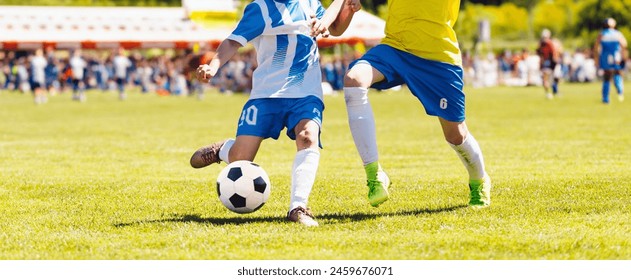 Young boys playing soccer game. Kids having fun in sport. Happy kids compete in football game. Running soccer players. Competition between players running and kicking football ball. Football school - Powered by Shutterstock