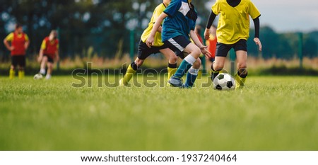Young boys playing soccer game. Kids having fun in sport. Happy kids compete in football game. Running soccer players. Competition between players running and kicking football ball. Football school Foto stock © 