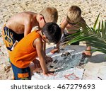 Young boys reading a pirate treasure map on the beach in Mexico