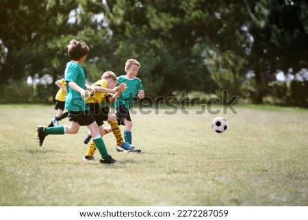 Young boys running after the ball during a soccer game