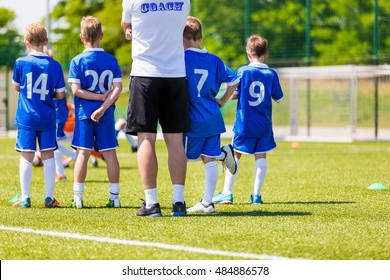 Young Boys In Soccer Football Team With Coach. Reserve Players On A Team Bench. Motivation Talk Before Soccer Match. Little League Soccer Boys Team.