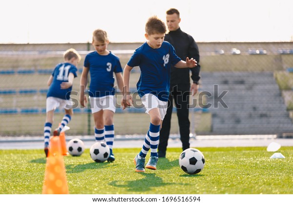 Young Boys in Sports Soccer Club on Training Unit.\
Kids Improve Soccer Skills on Natural Turf Grass Pitch. Football\
Practice Session for Children Youth Team. Junior Level Professional\
Soccer School