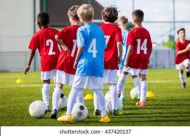 Young Boys Training Soccer Football on the Green Pitch of the Football Stadium.  Training session for youth boys team before the tournament soccer match. Young boys kicking soccer ball. - Powered by Shutterstock