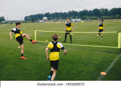 Young Boys In Youth Soccer Club Playing Football Tennis Training Game. Teenage Soccer Players Playing Football Tennis On Training Session. Teenagers Practicing Soccer On Grass Pitch. 