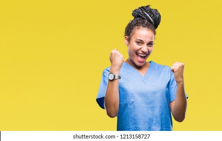 Young braided hair african american girl professional nurse over isolated background very happy and excited doing winner gesture with arms raised, smiling and screaming for success. Celebration - Powered by Shutterstock