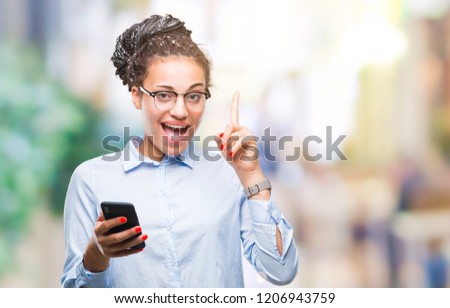 Young braided hair african american business girl using smartphone over isolated background surprised with an idea or question pointing finger with happy face, number one