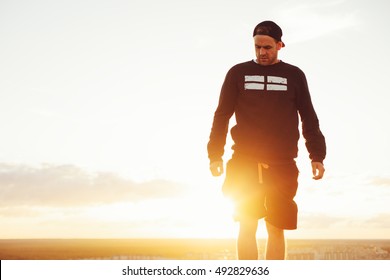 Young And Brave Man On The Top Of The Roof At Sunset