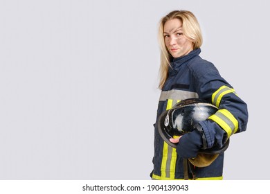 Young brave woman with dirty face in uniform of firefighter holds hardhat in hand and looking at camera isolated on gray background. Copy space for text  - Powered by Shutterstock