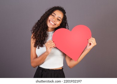 Young Brazilian Black Woman Holding Heart Shaped Sign, Publicity Photo.