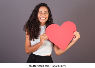 Young Brazilian Black Woman Holding Heart Shaped Sign, Publicity Photo.