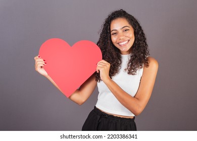 Young Brazilian Black Woman Holding Heart Shaped Sign, Publicity Photo.