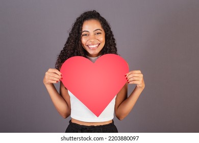 Young Brazilian Black Woman Holding Heart Shaped Sign, Publicity Photo.