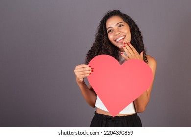 Young Brazilian Black Woman Holding Heart Shaped Sign, Publicity Photo.