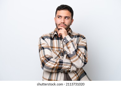 Young Brazilian man isolated on white background having doubts and thinking