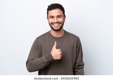 Young Brazilian man isolated on white background giving a thumbs up gesture - Powered by Shutterstock