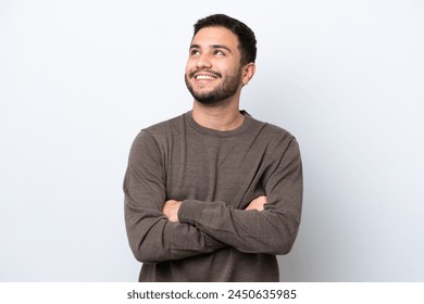 Young Brazilian man isolated on white background looking up while smiling - Powered by Shutterstock