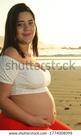 young brazilian pregnant woman on the beach at sunrise